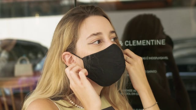 Woman taking her face mask off