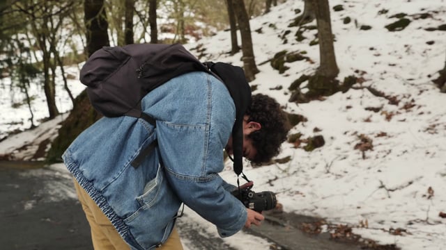 Man films a video in a snowy forest