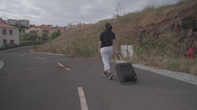Una niña camina por la calle con una maleta