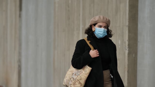Woman wearing a face mask and walking down the street