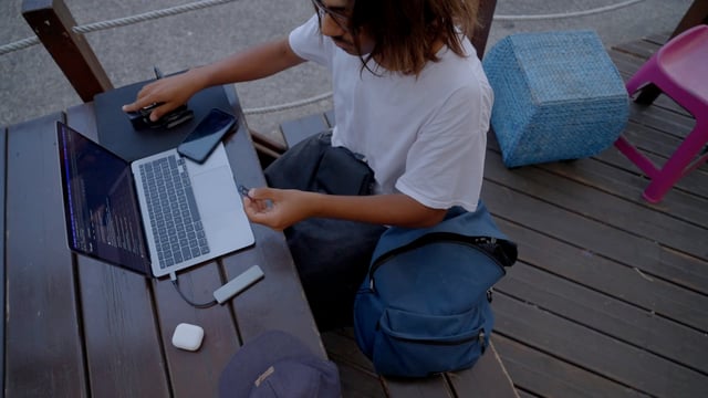 Un editor de video masculino coloca una tarjeta SD en una computadora portátil