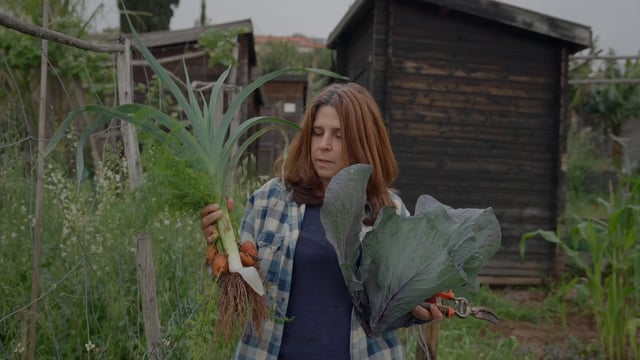 Una mujer lleva verduras recogidas en su croft