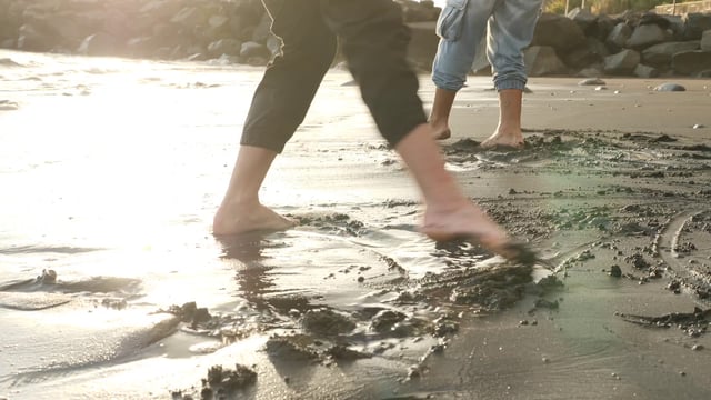 两只脚在潮湿的沙子里移动