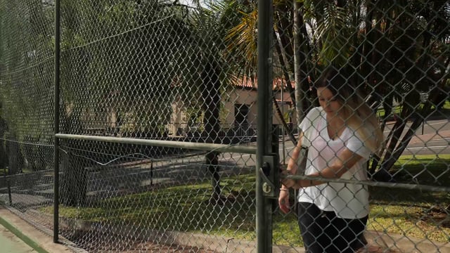 A woman walking onto the tennis court