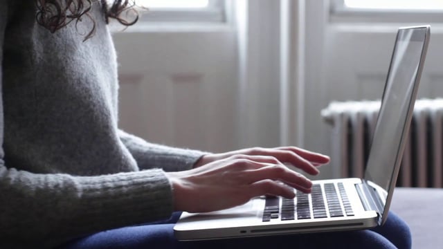 Woman typing on Macbook