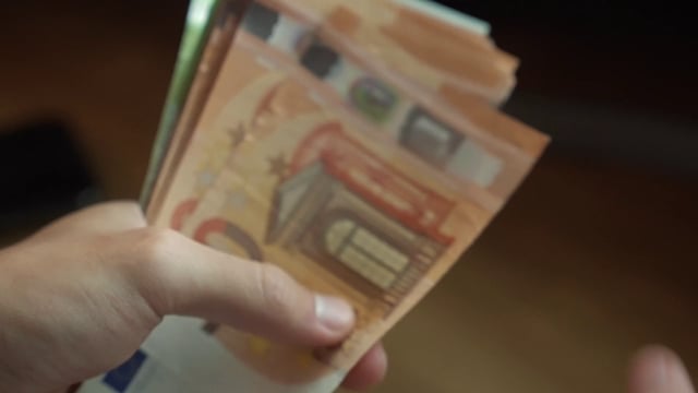 A man counting 50-euro banknotes