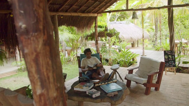 Man reading a book in his jungle home