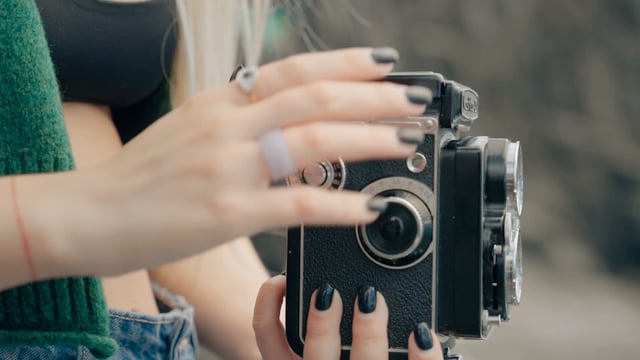 Una niña ajusta una vieja cámara para tomar fotos.