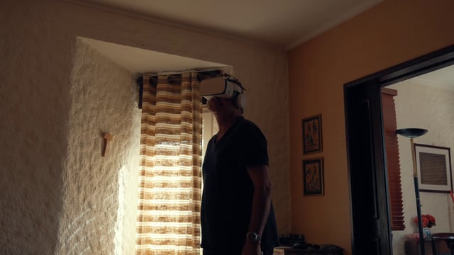 An adult man using VR glasses while standing