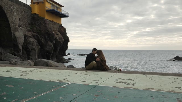Boyfriend and girlfriend sitting by the coast