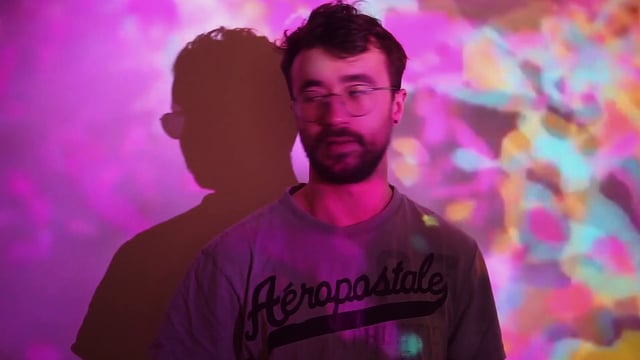 Hombre delante de un proyector colorido