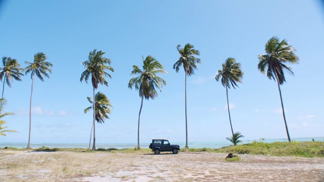 Land Rover estacionado en una playa tropical