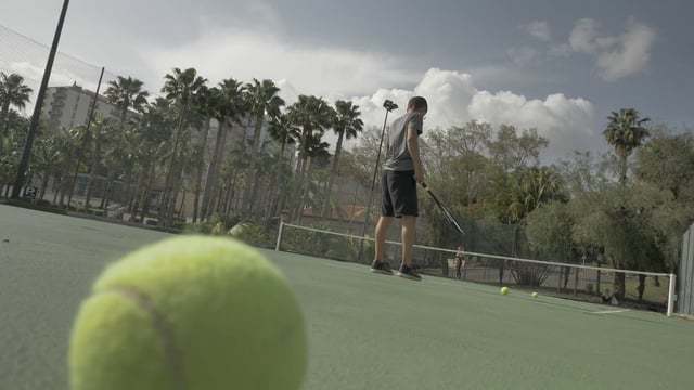 Man bouncing a tennis ball before serving