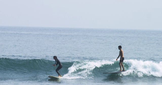 Un par de surfistas compartiendo una ola