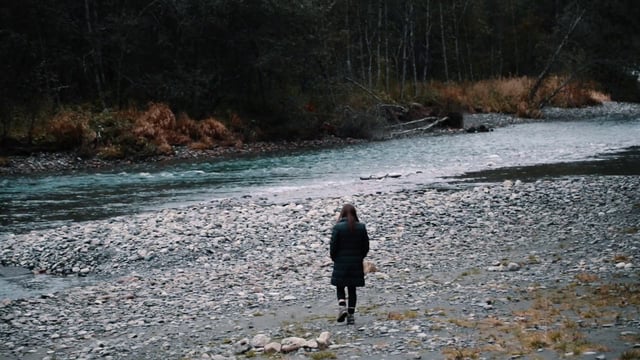 Mujer pasea cerca de un río