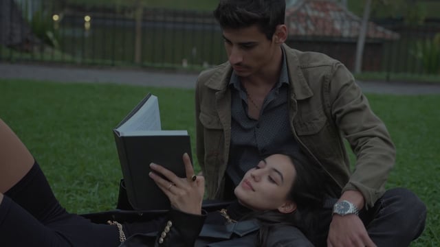 Una pareja lee un libro en un parque.
