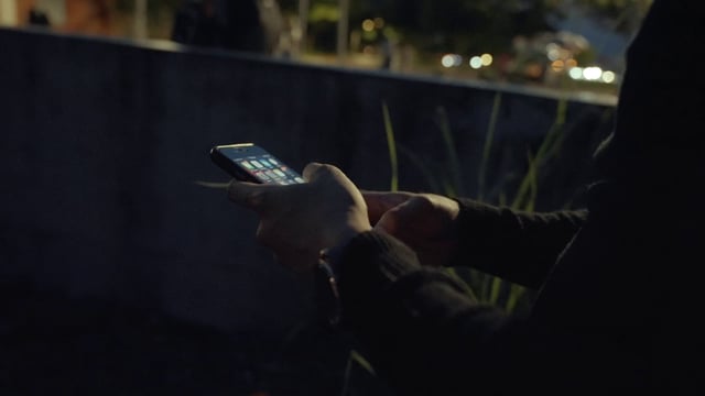 Person typing on a smartphone at night