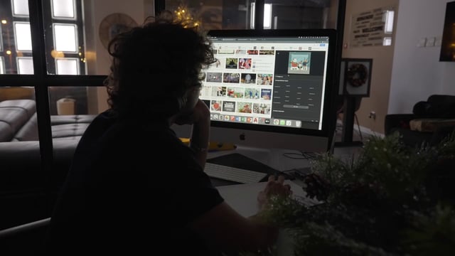 A man looking at Christmas pictures on his computer