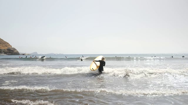Surfer girl enters the sea