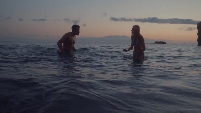 Una chica está jugando con su novio en el mar.