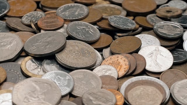 Many old coins fall on a pile