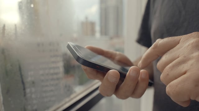 Male hands typing on a smartphone