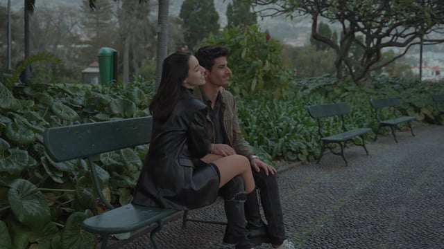 A loving couple sitting on a bench in a park