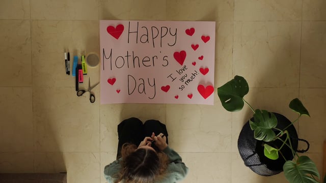 Vista superior de una niña hace un cartel para el día de la madre
