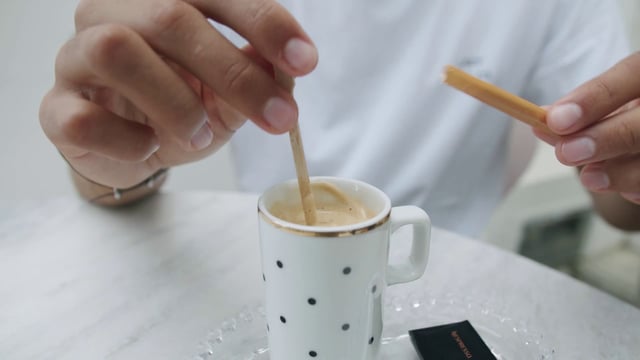 Pouring sugar in a cup of coffee