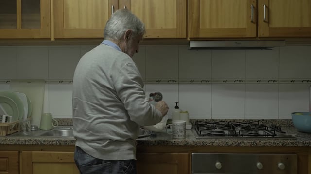 Old man pouring sugar into coffee