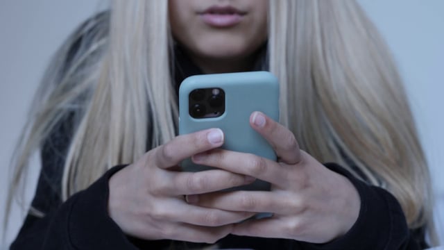 Girl using iPhone in bed 