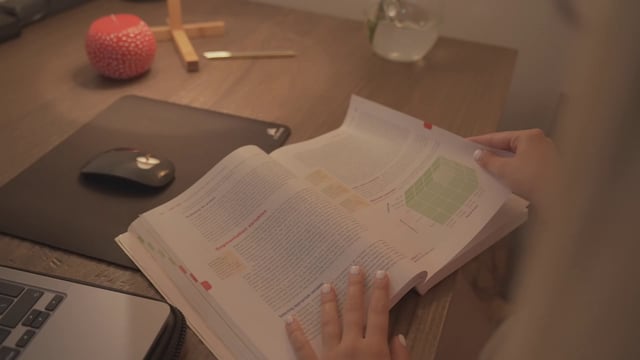 Student turning the pages of a marketing book