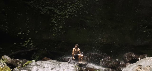 Sitting on a rock near the waterfall