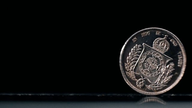 Brazilian coin spinning against a black background