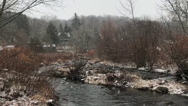 Nieve cayendo por un río