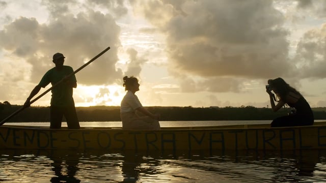 Mujeres fotografiando en una canoa al atardecer