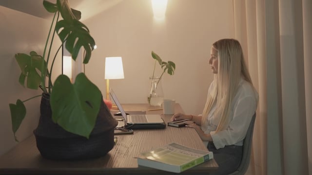 Una niña hace una videollamada en una computadora portátil en una oficina en casa