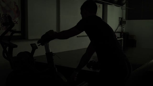 Un hombre prepara una bicicleta estática para hacer ejercicio