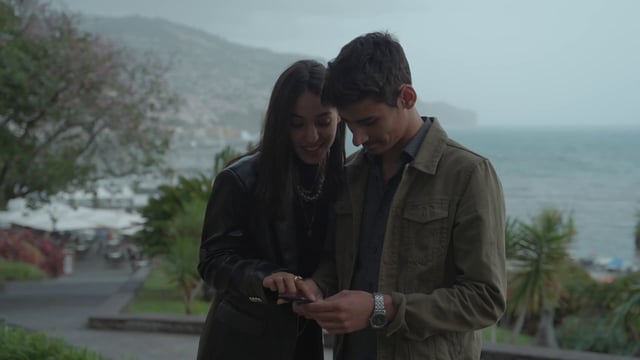 Una pareja mira algo en un teléfono inteligente