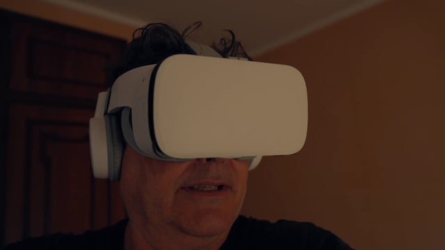 A senior man enthusiastically looking into his VR headset  