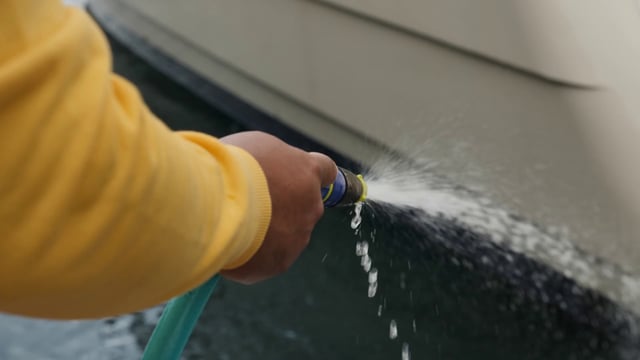 Cleaning a boat with a hose 