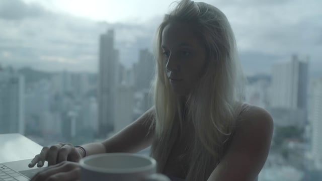 A girl working at her desk drinking coffee