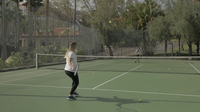 Woman playing tennis with a friend