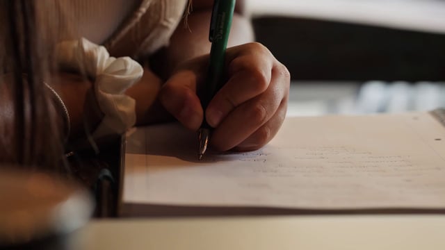 Student writing notes in a notebook