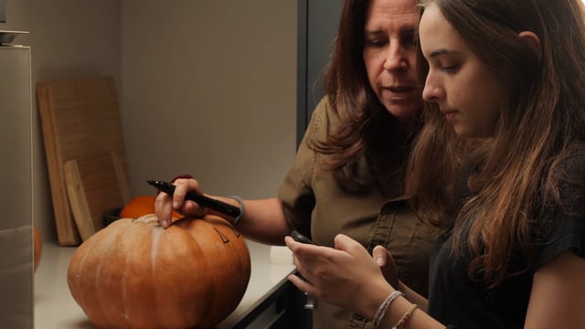 Mom and daughter looking at pumpkin designs