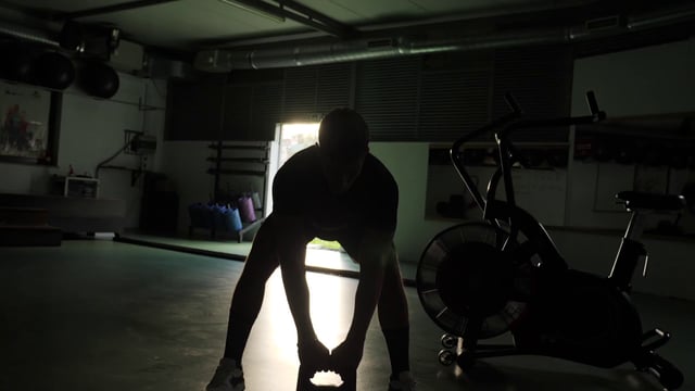 Hombre fuerte de fitness muscular se entrena con una pesa rusa