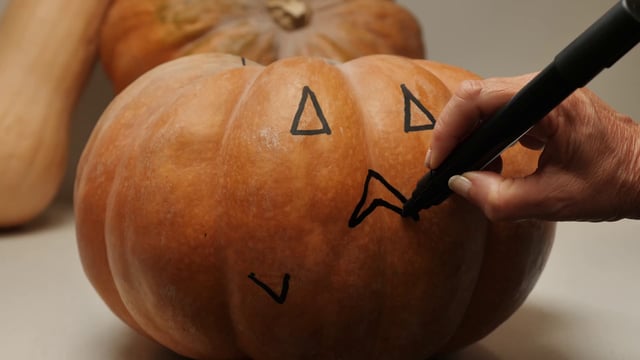 Drawing nose on a pumpkin