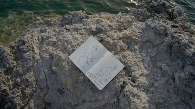 Un cuaderno de dibujo de pintura sobre una piedra
