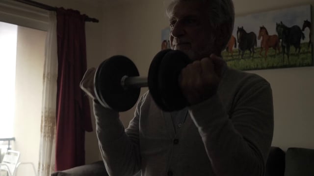 Un abuelo entrena levantando una mancuerna