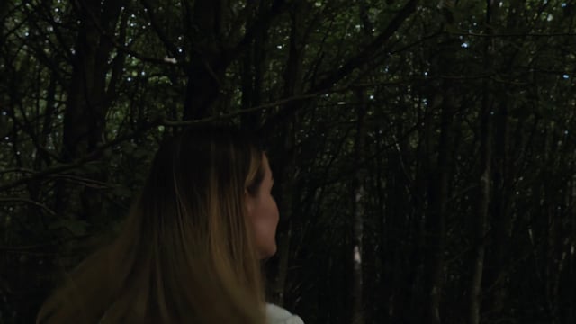 Woman running in a dark forest